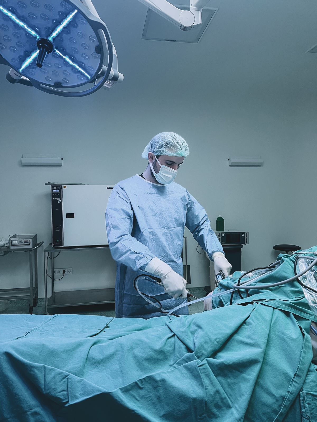 Profissional de saúde realizando procedimento endoscópico em sala cirúrgica equipada